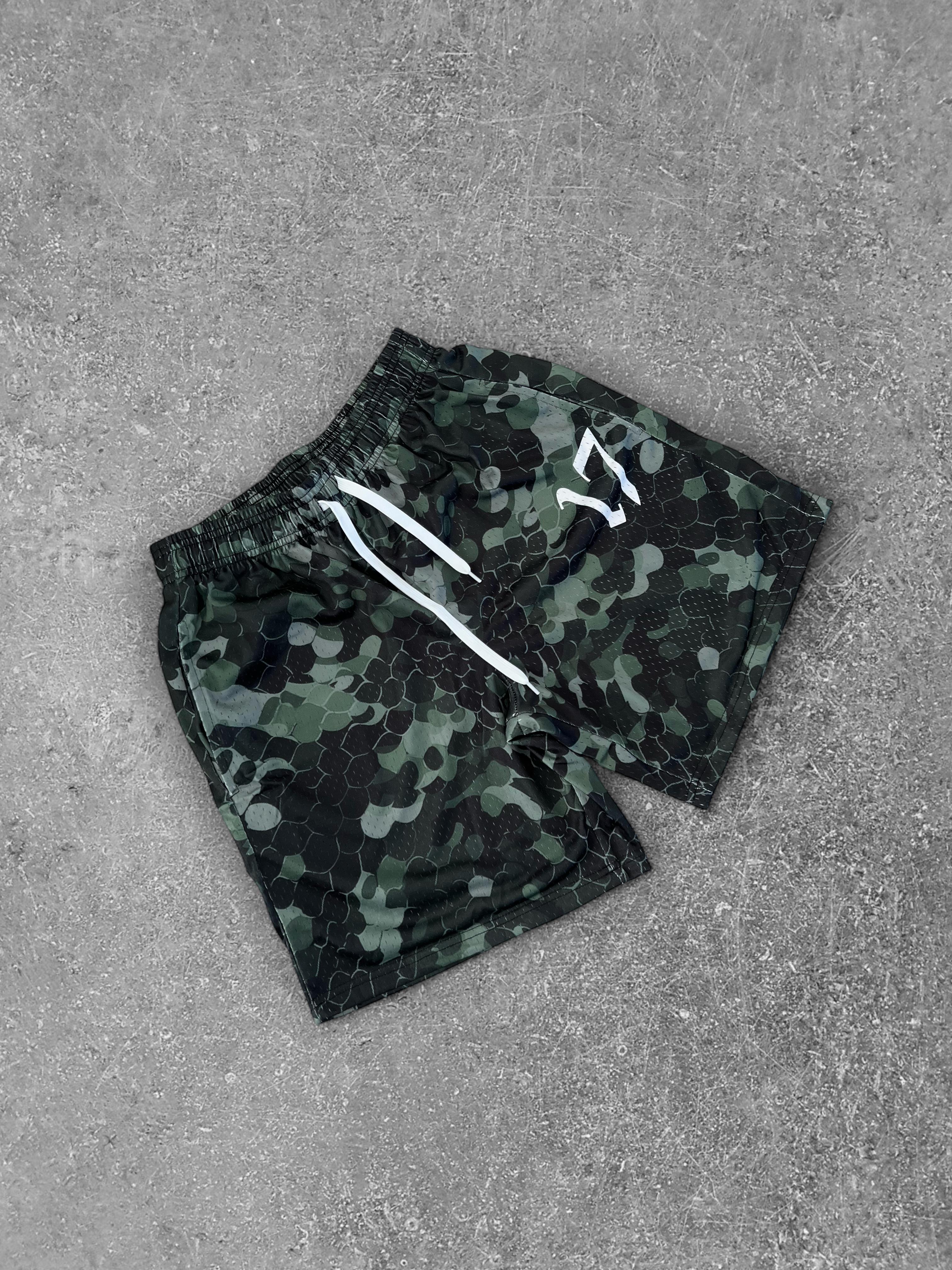 Camouflage shorts with white drawstring on a gray surface